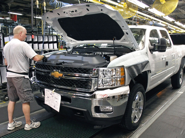 A worker assembles a Silverado truck on the assembly line at the GM Flint Assembly plant in Michigan.