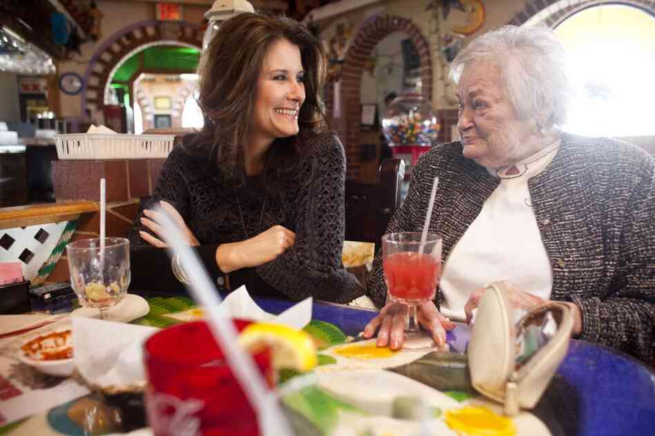 Kelley Hawkins (left) smiles with her grandmother AnnaBelle Bowers, 87, while at lunch in Harrisburg, Pa. Kelley shares full-time care of AnnaBelle with her sister-in-law LaDonna Martin. Both are nurses with two children each, and move Annabelle, who has limited mobility, every two weeks from one home to another.