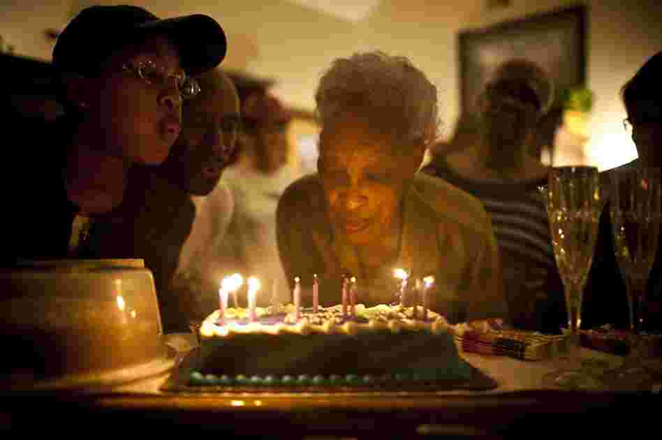 Ida Christian, who suffers from dementia, gets help from her granddaughter, Yolanda Hunter (left), in blowing out the candles on her birthday cake. Yolanda quit her lucrative job to become Ida's full-time caregiver.