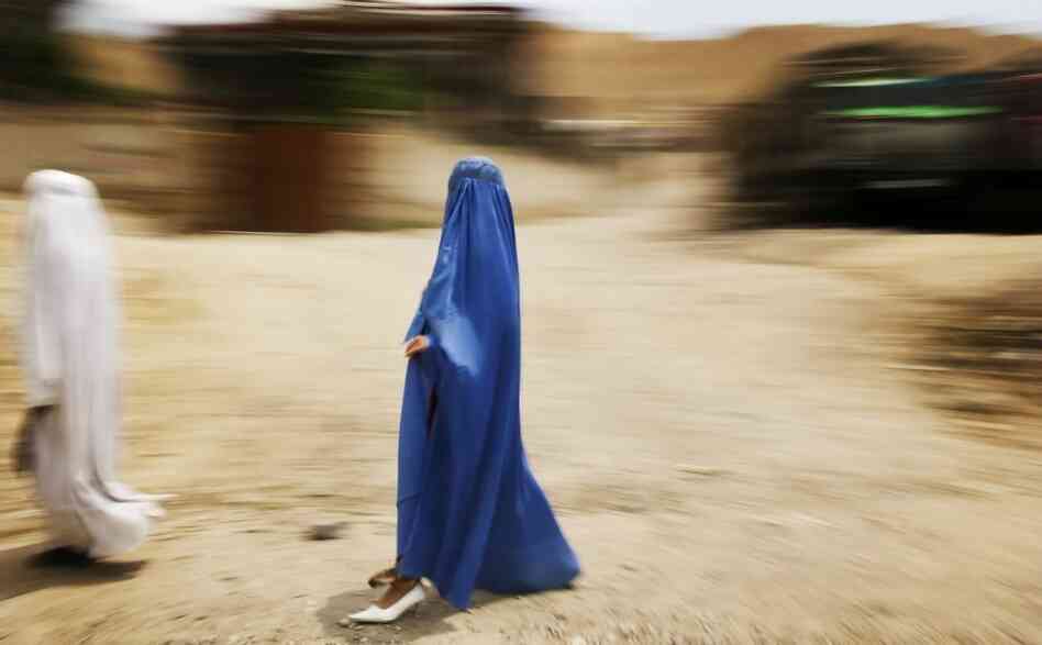 A women reveals a high-heeled shoe on the roadside between Kunduz and Mazar-e-Sharif, Afghanistan. A women reveals a high-heeled shoe on the roadside between Kunduz and Mazar-e-Sharif, Afghanistan.