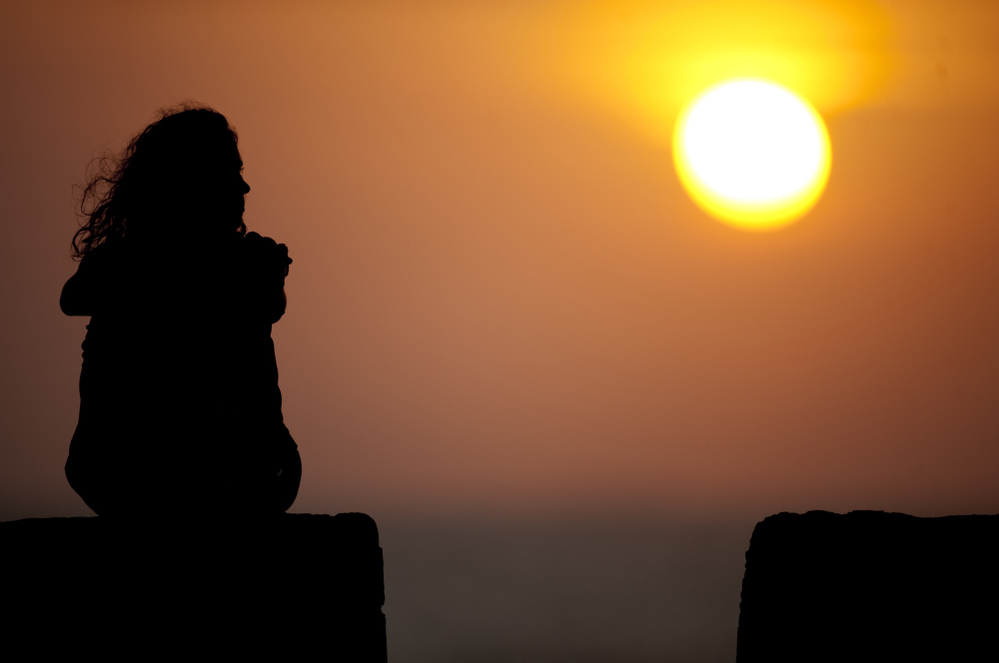 A tourist sits at the Old Fortresss in Cartagena, Colombia during sunset on April 14, 2012.
