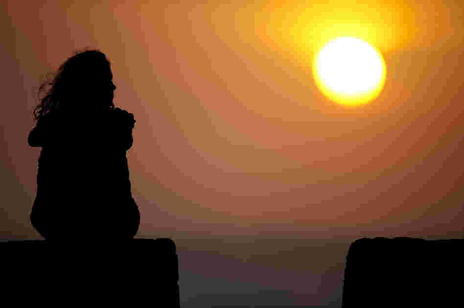 A tourist sits at the Old Fortresss in Cartagena, Colombia during sunset on April 14, 2012.