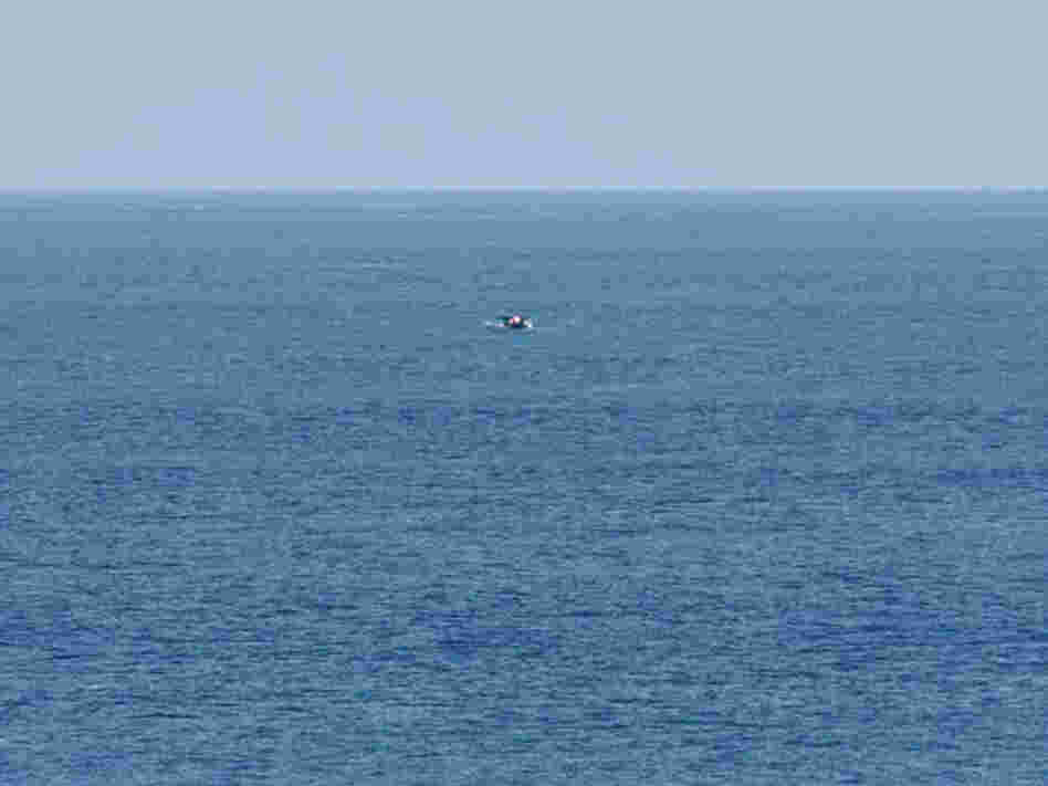 Bird-watcher Jeff Gilligan snapped this photograph of a small boat in distress. Gilligan and others say the cruise ship he was traveling on did not stop to help the stricken craft.