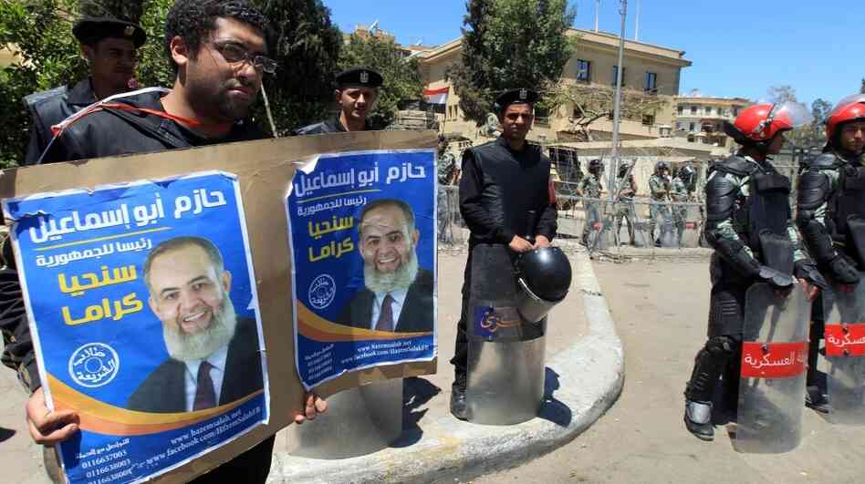 Egyptian military police stand by as a protester holds a placard in support of Salafist presidential candidate Hazem Abu Ismail at a demonstration outside the High Presidential Election Committee building Tuesday in Cairo. Ismail and nine other candidates have been disqualified from the race. Egyptian military police stand by as a protester holds a placard in support of Salafist presidential candidate Hazem Abu Ismail at a demonstration outside the High Presidential Election Committee building Tuesday in Cairo. Ismail and nine other candidates have been disqualified from the race.