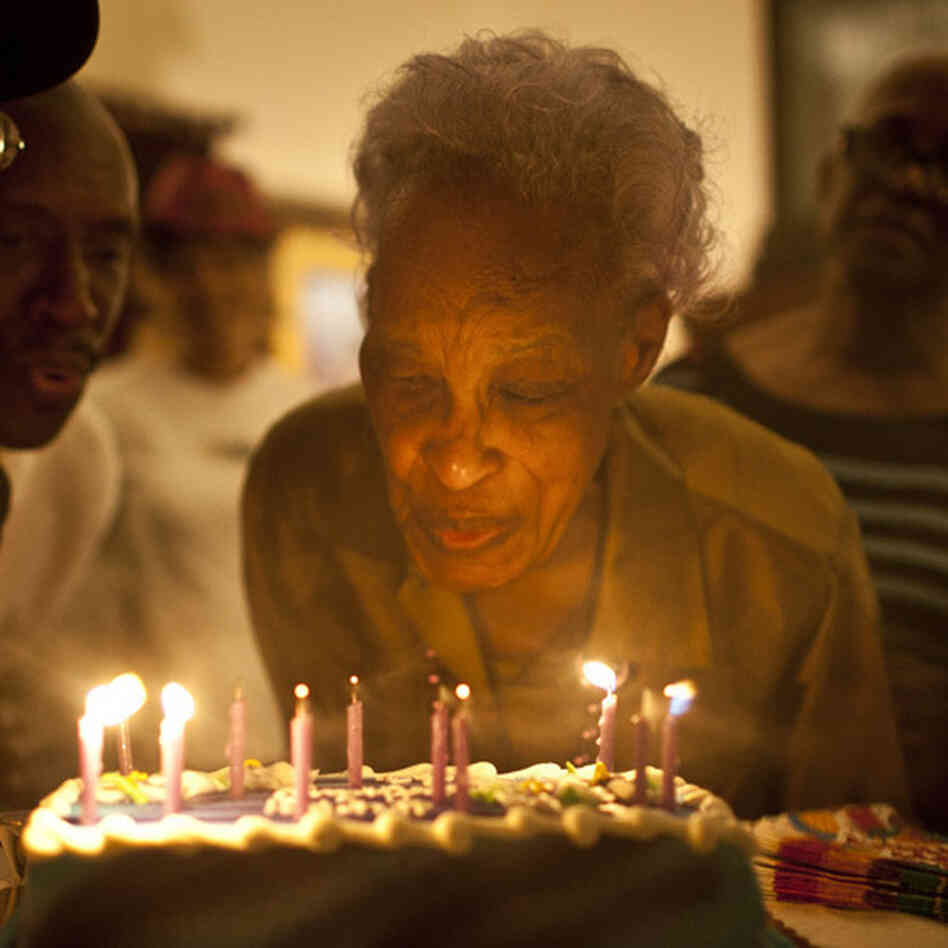 Ida Christian, 89, gets help from her granddaughter, Yolanda Hunter (left), in blowing out the candles on her birthday cake.