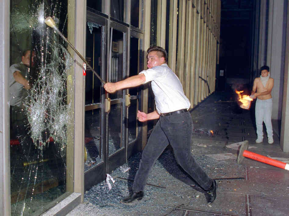A rioter breaks glass at the Criminal Courts building in Los Angeles on April 29, 1992, after a jury acquitted four police officers accused of beating Rodney King.