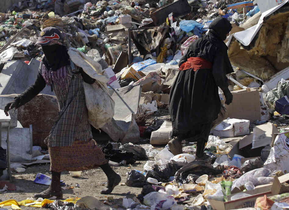 People sift through trash at a garbage dump in Baghdad, Iraq. 