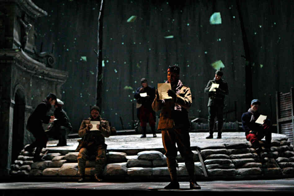 French, German and Scottish soldiers sing choruses in their native languages as they write home.