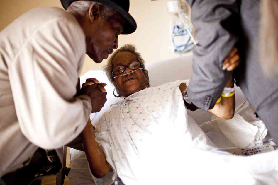 Franklin Brunson (left) and Curtis Gilmore help Natasha's mother, Luella Brunson, sit upright in her hospital bed. Along with caring for her aging father, Natasha keeps a close eye on her 80-year-old mother, who is often hospitalized with complications from chronic obstructive pulmonary disease.