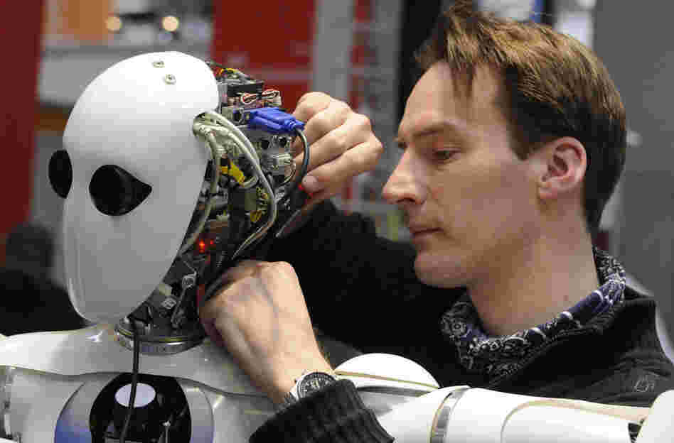 A technician works on the DFKI robot AILA at a German trade fair in 2010.