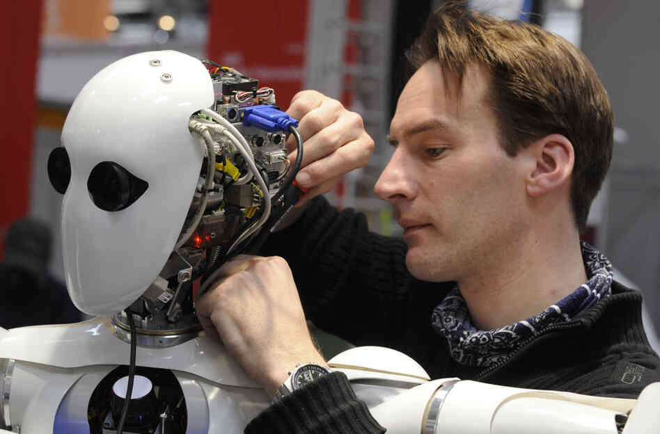 A technician works on the DFKI robot AILA at a German trade fair in 2010.