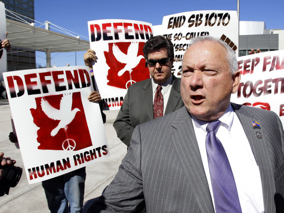 Protesters gather around then-state Sen. Russell Pearce, who sponsored Arizona's immigration law, outside the Sandra Day O'Connor federal courthouse in Phoenix in 2011.
