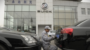A mechanic works on a Buick at a General Motors dealership in Shanghai last December. GM just announced it plans to open 600 additional dealerships in China. The company now sells more cars in China than it does in the United States.
