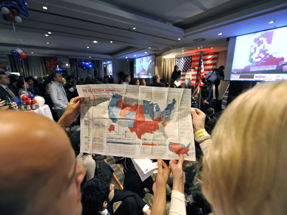 Onlookers study a map of the electoral college system during a Nov. 5, 2008, U.S. presidential election party in Brussels. This year, the electoral vote landscape could be more challenging for Mitt Romney than national popular vote polls might suggest.