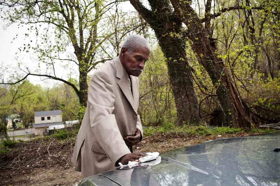 Franklin wipes pollen from the family car in their driveway before heading to church on a Sunday morning. He talks often about missing his independence, especially his ability to drive.