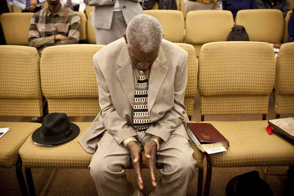 Franklin prays during Sunday worship. "I got aches and pains but I can still walk around," he says.