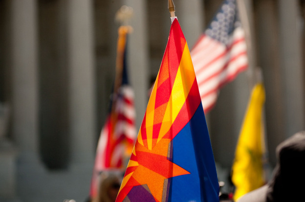 Supporters of Arizona's immigration law fly the flags of the state (center), the United States and the Tea Party on the steps of the Supreme Court during oral arguments about the law on Wednesday.