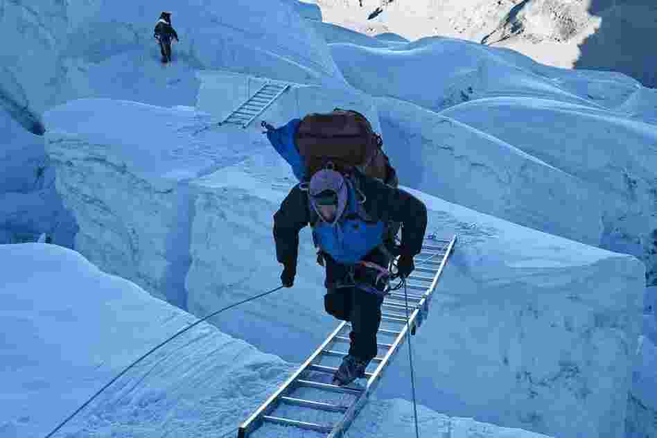 At dawn, a Sherpa runs uphill across a ladder spanning a crevasse at the top of the Khumbu Icefall, April 21.