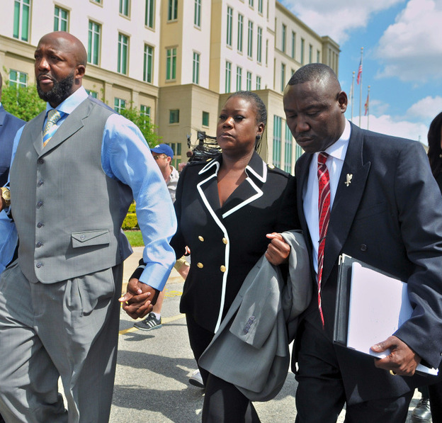 Tracy Martin and Sybrina Fulton, the parents of Trayvon Martin, walk with attorney Benjamin Crump and others as they leave the Seminole County courthouse after the bond hearing for George Zimmerman.