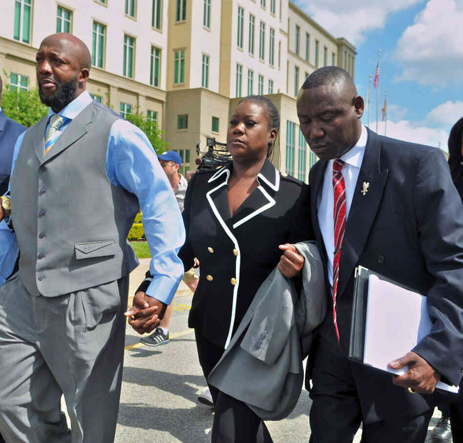 Tracy Martin and Sybrina Fulton, the parents of Trayvon Martin, walk with attorney Benjamin Crump and others as they leave the Seminole County courthouse after the bond hearing for George Zimmerman.