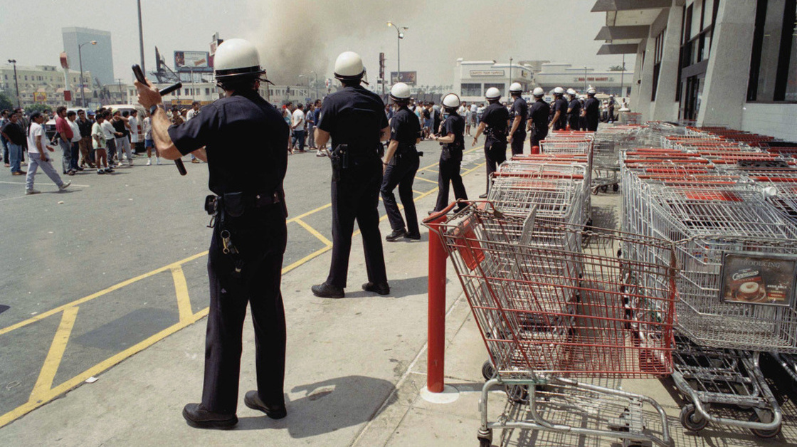 Los Angeles police form a line to keep a crowd from entering a building on April 30, 1992. Twenty years after the L.A. riots, most civil rights and community groups give the LAPD high marks for progress.