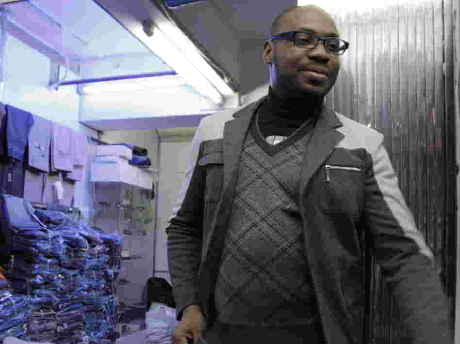 A trader who goes by the name Fortunato — he says it's his "designer name" — stands outside one of the clothing shops in the Little Africa section of Guangzhou. He's been living in the Chinese city for five years.