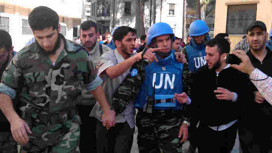 Members of the Syrian opposition walk with a U.N. observer during a visit by monitors to the restive city of Homs, Syria, on April 21. Opposition activists say observers appear to help bring calm if they stay in an area. Two monitors have been deployed in Homs for the past several days. Members of the Syrian opposition walk with a U.N. observer during a visit by monitors to the restive city of Homs, Syria, on April 21. Opposition activists say observers appear to help bring calm if they stay in an area. Two monitors have been deployed in Homs for the past several days.