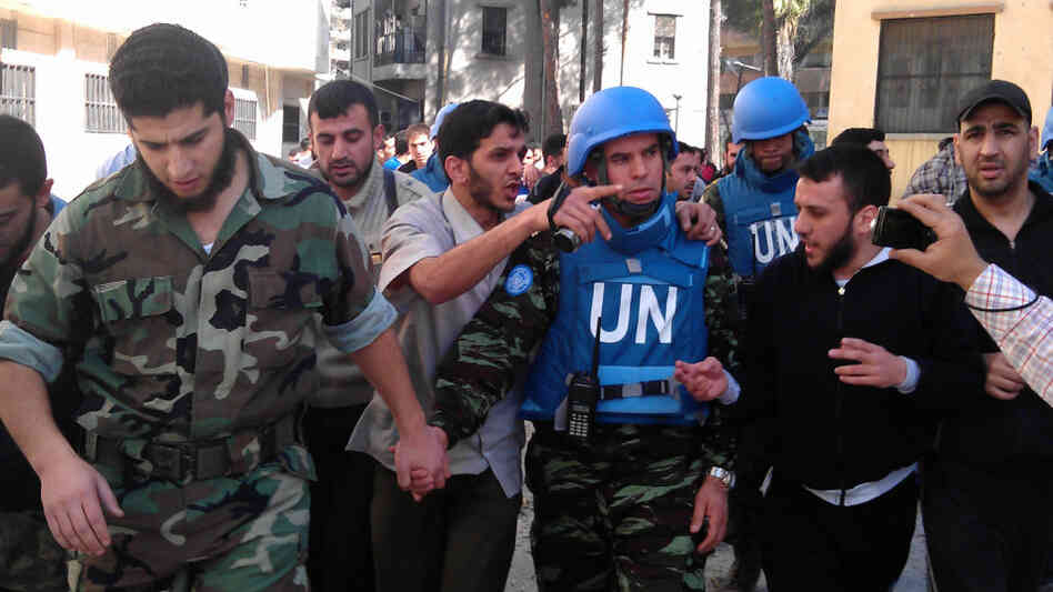 Members of the Syrian opposition walk with a U.N. observer during a visit by monitors to the restive city of Homs, Syria, on April 21. Opposition activists say observers appear to help bring calm if they stay in an area. Two monitors have been deployed in Homs for the past several days. Members of the Syrian opposition walk with a U.N. observer during a visit by monitors to the restive city of Homs, Syria, on April 21. Opposition activists say observers appear to help bring calm if they stay in an area. Two monitors have been deployed in Homs for the past several days.