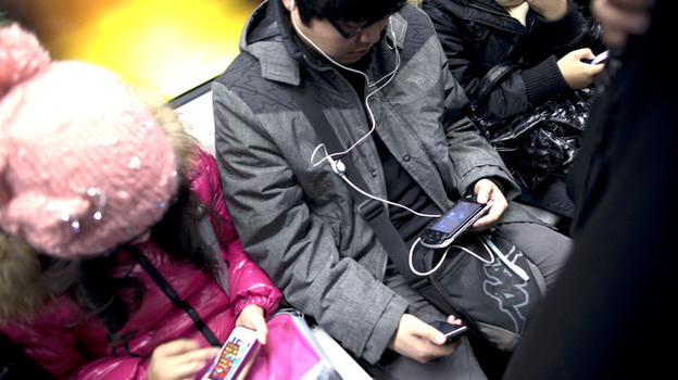 Commuters immersed in their smartphones ride the subway in Beijing. (Bloomberg via Getty Images)