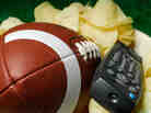 A football and a television remote sit expectantly in a bowl of chips, waiting for an NFL Draft fan to claim them.