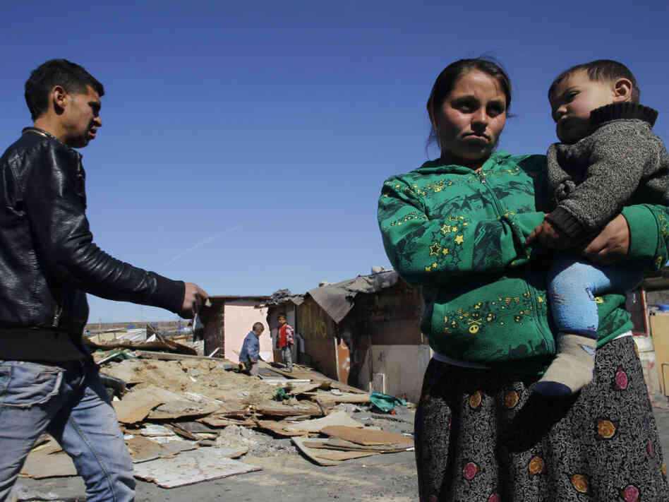 Residents of Cañada Real stand near recently demolished shacks on March 5. The settlement is separated into different sections and tends to be segregated by ethnic groups: Roma in one section, Arabs in another, for example.