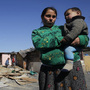 Residents of Cañada Real stand near recently demolished shacks on March 5. The settlement is separated into different sections and tends to be segregated by ethnic groups: Roma in one section, Arabs in another, for example.