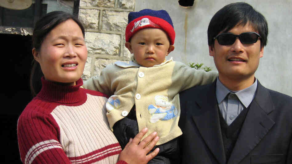 Blind activist Chen Guangcheng with his wife and son outside their home in northeast China's Shandong province in 2005.