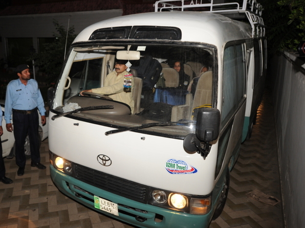 Pakistani policemen escort a minivan carrying family members of slain al-Qaeda chief Osama bin Laden, in Islamabad, earlier today.