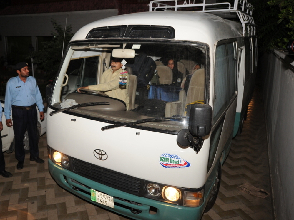 Pakistani policemen escort a minivan carrying family members of slain al-Qaeda chief Osama bin Laden, in Islamabad, earlier today.