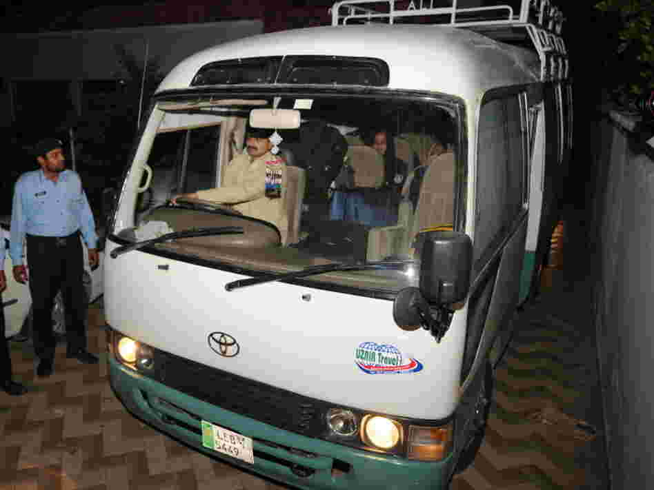 Pakistani policemen escort a minivan carrying family members of slain al-Qaeda chief Osama bin Laden, in Islamabad, earlier today.