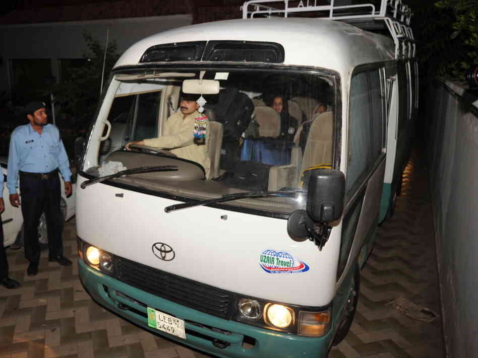 Pakistani policemen escort a minivan carrying family members of slain al-Qaeda chief Osama bin Laden, in Islamabad, earlier today.