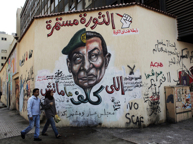A mural in Cairo depicts the split faces of Egyptian military ruler Field Marshal Hussein Tantawi, left, and ousted president Hosni Mubarak accompanied by Arabic that reads, "who assigned you did not die, No for gas export to Israel, the revolution continues."
