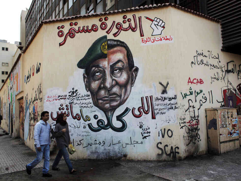 A mural in Cairo depicts the split faces of Egyptian military ruler Field Marshal Hussein Tantawi, left, and ousted president Hosni Mubarak accompanied by Arabic that reads, "who assigned you did not die, No for gas export to Israel, the revolution continues."