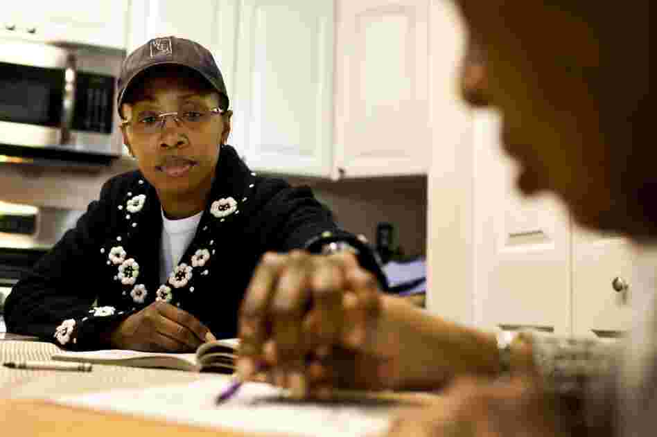 Yolanda, 43, helps Ida color at the family's kitchen table. She has been taking care of her grandmother daily for over two years and insists it is the best care for Ida.