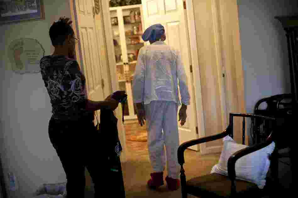 Yolanda waits as Ida gingerly walks into the bathroom during their morning routine. According to Yolanda, some days Ida argues with her and refuses to get out of bed.