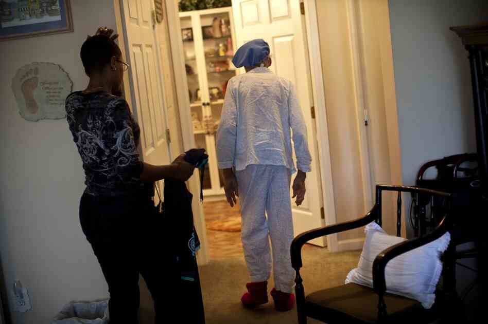 Yolanda waits as Ida gingerly walks into the bathroom during their morning routine. According to Yolanda, some days Ida argues with her and refuses to get out of bed.