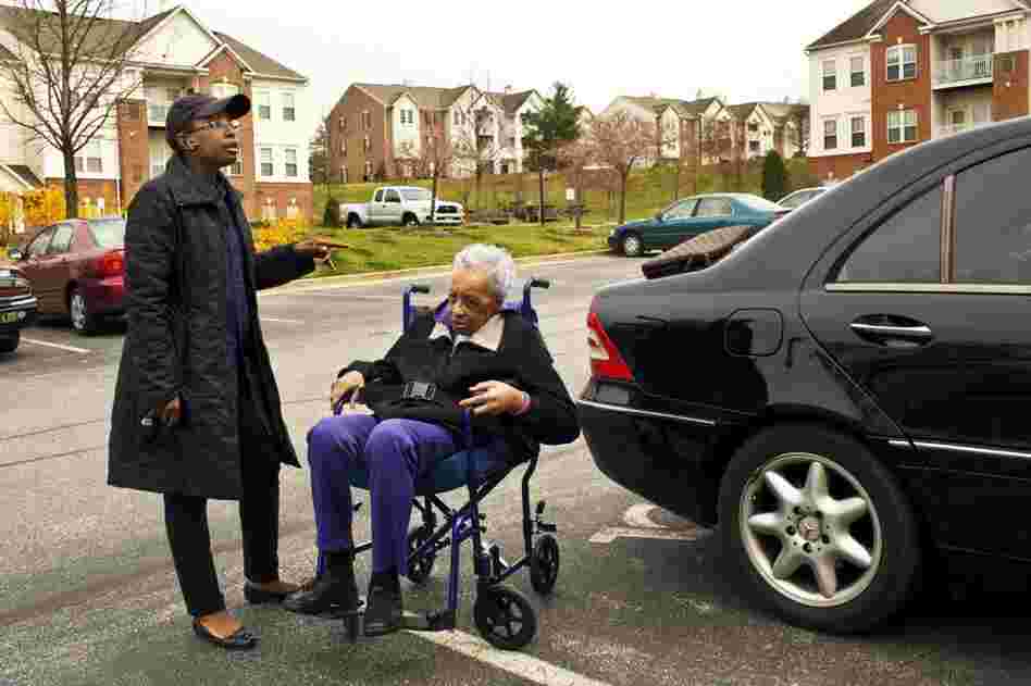 Yolanda takes a business call in the parking lot outside Geneva's home. She had only planned to take a year off from her lucrative career in human resources, and is now trying to get back into the workforce.