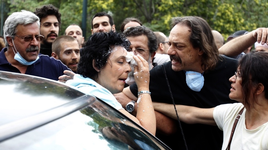 Communist Party of Greece lawmaker Liana Kanelli enters her car after protesters threw yogurt at her as she tried to reach the Greek Parliament on June 29, during a 48-hour general strike in Athens. Such attacks are not uncommon in Greece, where ordinary Greeks' anger over the debt crisis and austerity measures is boiliing over.