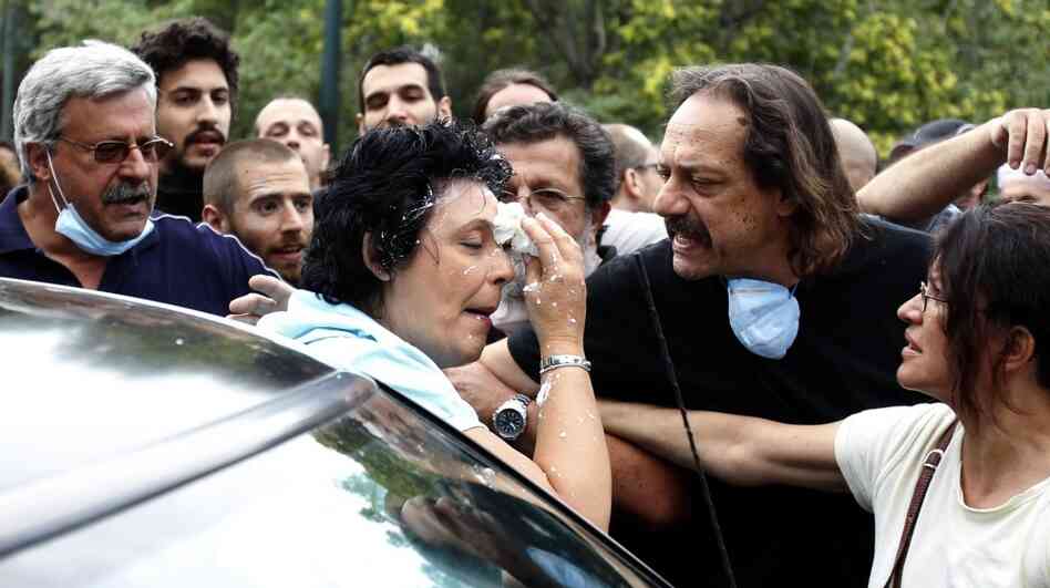 Communist Party of Greece lawmaker Liana Kanelli enters her car after protesters threw yogurt at her as she tried to reach the Greek Parliament on June 29, during a 48-hour general strike in Athens. Such attacks are not uncommon in Greece, where ordinary Greeks' anger over the debt crisis and austerity measures is boiliing over.