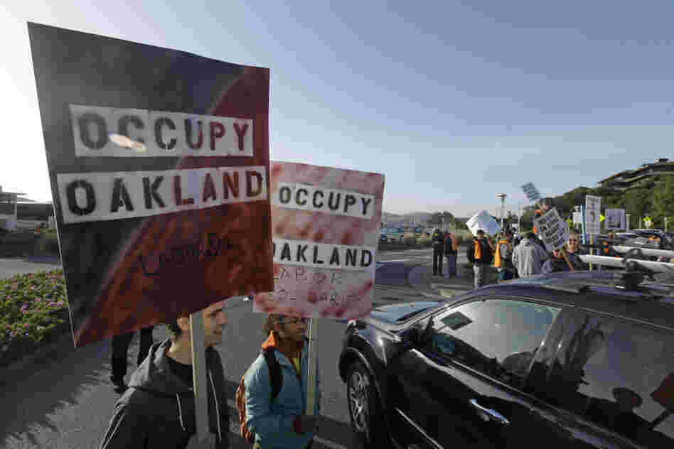 Two members of Occupy Oakland join striking Golden Gate Bridge, bus and ferry workers at the Larkspur Ferry Terminal in Larkspur, Calif on Tuesday.