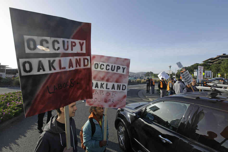 Two members of Occupy Oakland join striking Golden Gate Bridge, bus and ferry workers at the Larkspur Ferry Terminal in Larkspur, Calif on Tuesday.