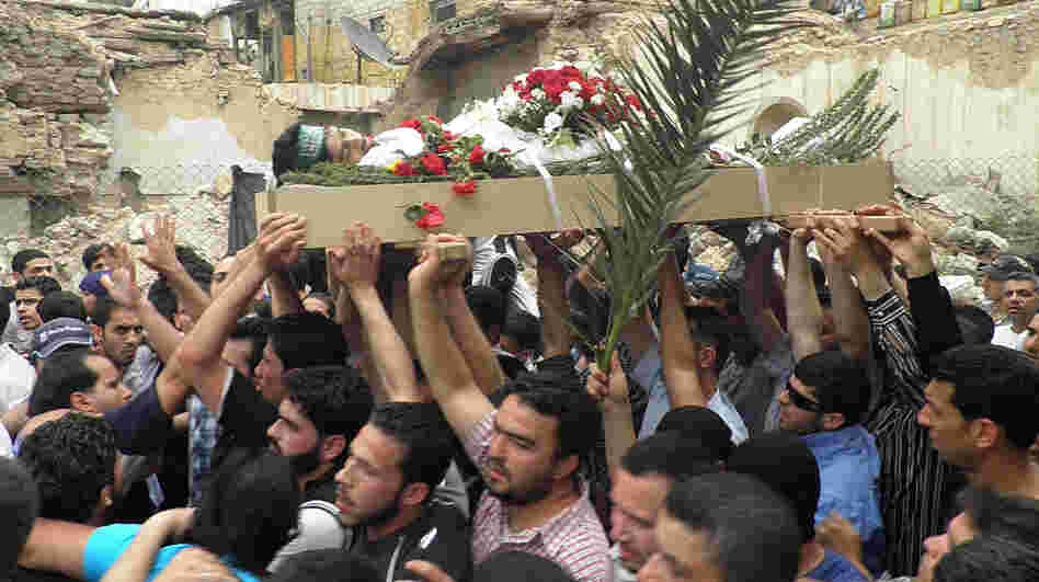 Mourners carry the body of activist Nour Hatem Zahra, 23, during his funeral procession, in Damascus, Syria, on Monday. Friends and fellow activists say Zahra, who posted anti-government graffiti all around the Syrian capital, bled to death after being shot by Syrian security forces on Sunday. Mourners carry the body of activist Nour Hatem Zahra, 23, during his funeral procession, in Damascus, Syria, on Monday. Friends and fellow activists say Zahra, who posted anti-government graffiti all around the Syrian capital, bled to death after being shot by Syrian security forces on Sunday.