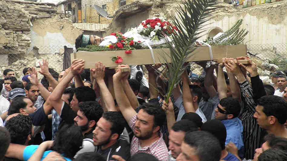 Mourners carry the body of activist Nour Hatem Zahra, 23, during his funeral procession, in Damascus, Syria, on Monday. Friends and fellow activists say Zahra, who posted anti-government graffiti all around the Syrian capital, bled to death after being shot by Syrian security forces on Sunday. Mourners carry the body of activist Nour Hatem Zahra, 23, during his funeral procession, in Damascus, Syria, on Monday. Friends and fellow activists say Zahra, who posted anti-government graffiti all around the Syrian capital, bled to death after being shot by Syrian security forces on Sunday.