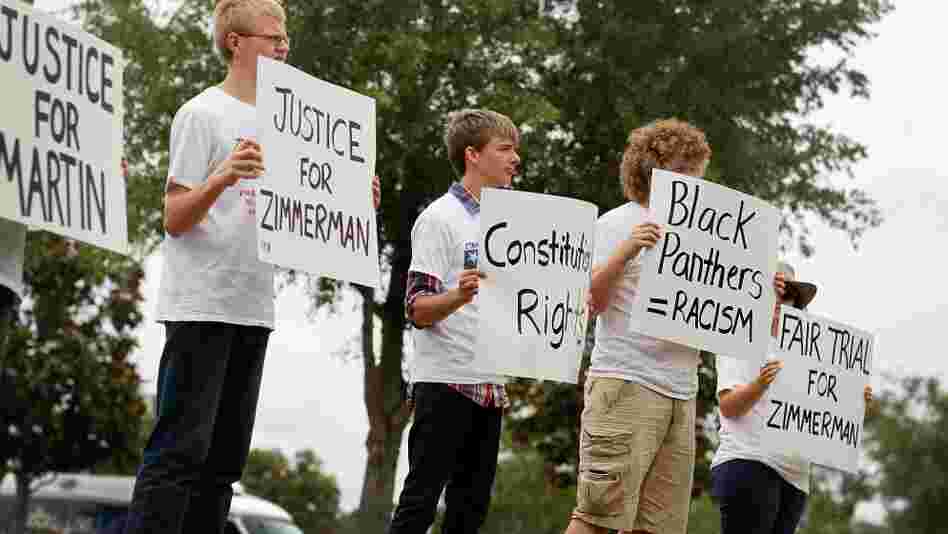People hold signs during a small April rally in Sanford, Fla., that was billed as an opportunity to show support for the constitutional rights of George Zimmerman and Trayvon Martin.